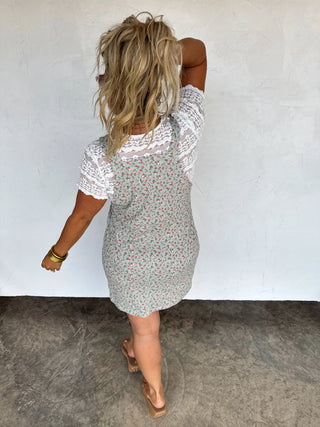 Woman wearing a floral dress against a plain background