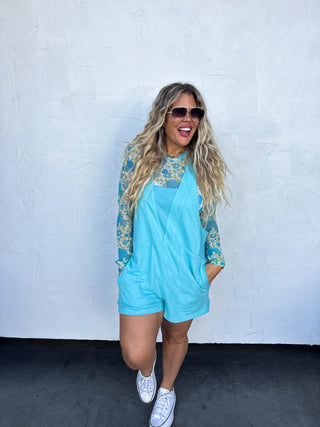 Woman wearing the Beach Please Romper styled casually with sandals and a beach bag for a relaxed summer look.