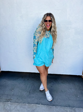 Woman wearing the Beach Please Romper styled casually with sandals and a beach bag for a relaxed summer look.