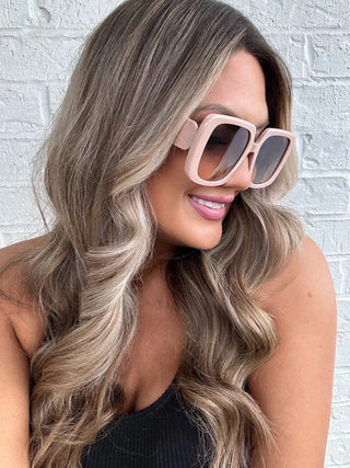 Model wearing Bora Bora Babe Sunglasses with beachy waves and a carefree summer vibe in blush.