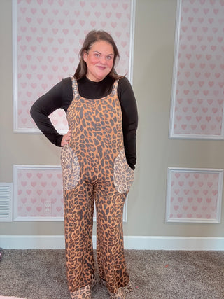 Person wearing a leopard print overalls standing in front of a mirror.