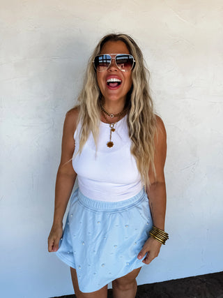 Model walking outdoors in the Pretty in Pearls Skort paired with a white tank.