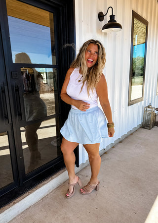 Model wearing blue pearl-embellished skort with elastic waistband and flowy skirt overlay.