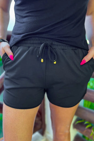 Adult After Dark Black Drawstring Everyday Shorts with a mid-rise fit, tie waist drawstring, side pockets, and a relaxed fit, made from a soft and stretchy 85% Polyester and 15% Spandex blend.
