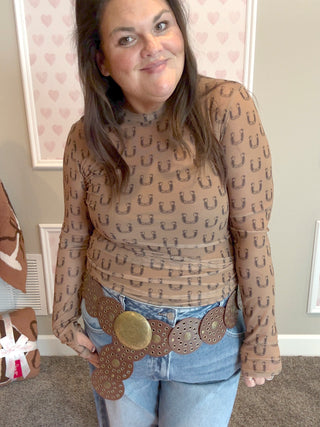 Model wearing the Black Horseshoe Mesh Top with thumbhole sleeves and a fitted silhouette, styled with denim jeans for a trendy western-inspired fall look.