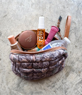 Makeup bag with various cosmetic products on a textured surface