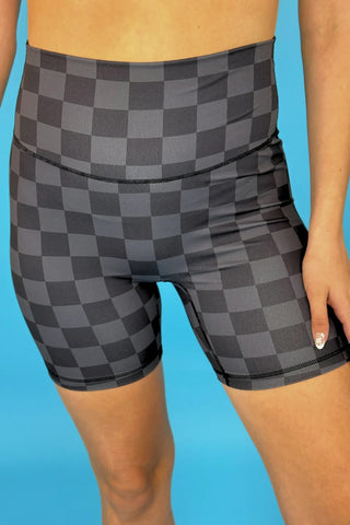 Close-up of chocolate checkered print fabric on biker shorts, showing soft and stretchy texture.