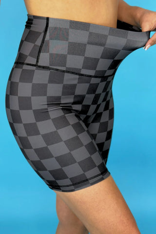 Side view of model in chocolate checkered biker shorts, highlighting high-rise waistband and 7" inseam.