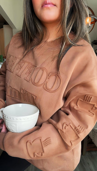 Woman wearing the Evelyn Embossed Sweatshirt - Coffee Time, styled casually with jeans for a fun, comfy look.