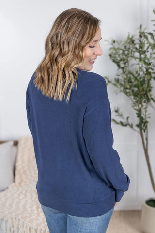 Back view of the Corrine Pullover showcasing long sleeves, ribbed fabric detail, and soft drape for a cozy yet flattering fit.