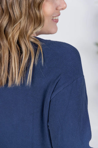 Close-up image highlighting the ribbed texture and rich navy color of the Corrine Pullover. Shows soft, stretchy fabric and stitching detail near the neckline and shoulder.