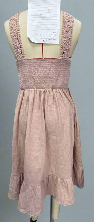 Close-up of intricate crochet detailing on the bodice and soft fabric of the maxi-length skirt.