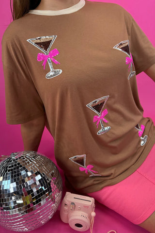 Up close of model lounging in the Espresso Martini Tee styled casually with Pink Nova Denim Skirt.