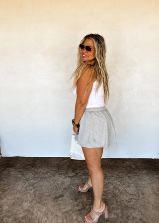 Model wearing gray pearl-embellished skort with elastic waistband and flowy skirt overlay.