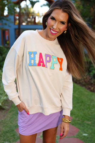 Front view of cozy pullover with soft fabric and cheerful smiley face patch design.