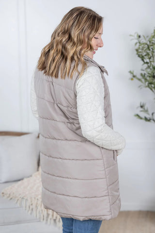 Back view of the latte Harlow Vest highlighting its longline cut and lightweight quilted texture.