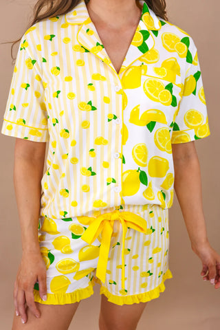 Yellow and white pajama set with lemon pattern on a brown background