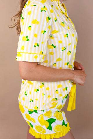 Yellow and white outfit with lemon pattern on a beige background