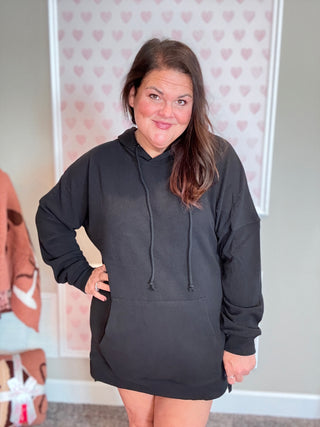 Close-up of ribbed fabric and cuffed sleeve of the Kacey Hoodie in black, with subtle texture visible.