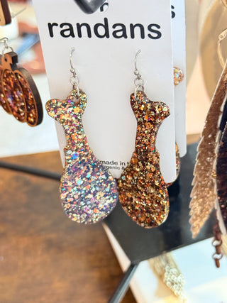 Acrylic turkey leg–shaped earrings covered in chunky autumn-toned glitter, displayed on a “randans” branded card.