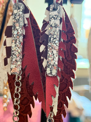 Decorative hair barrettes with feather design and glittery accents.