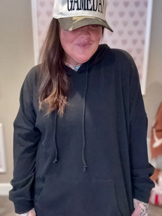 Close-up of ribbed fabric and cuffed sleeve of the Kacey Hoodie in black, with subtle texture visible.