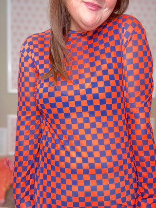 Model wearing blue and orange check pattern mesh top, women’s clothing trend.