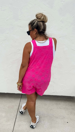 Woman wearing the Cambrie Pocket Romper, styled casually with sneakers for a relaxed, chic look.