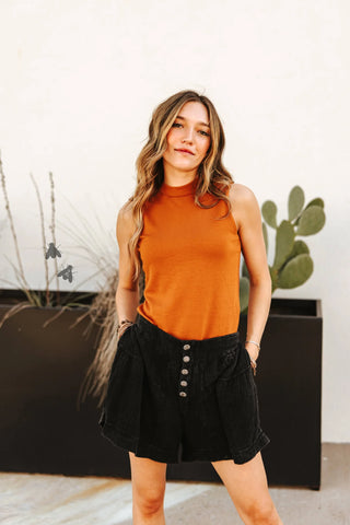 Flowy midnight black cotton shorts with concho button detail and elastic back waistband. Western-inspired design styled for comfort and movement.