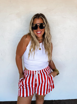 Close-up of red and white striped cotton fabric and waistband details on the shorts.