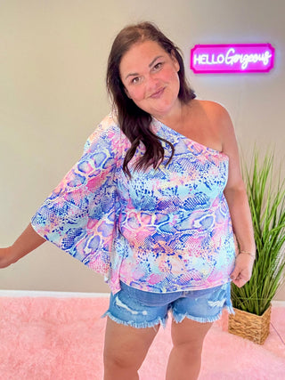 Model wearing Sassy Moment Colorful Snake Top with one-shoulder silhouette and vibrant snake print.
