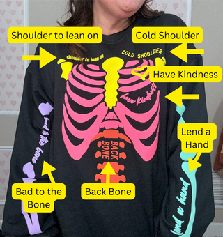 Black long-sleeve shirt with pink skeleton design and text, worn by a person.