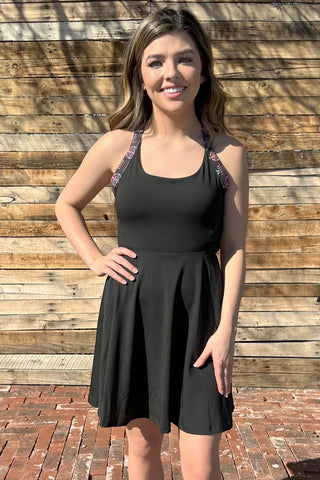 Woman wearing the Small Town Girl Tennis Dress styled with sneakers for a sporty, casual look.