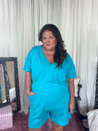 Woman wearing the Zenana Drop Shoulder V-Neck Romper with Pockets, styled casually for a laid-back, chic look.