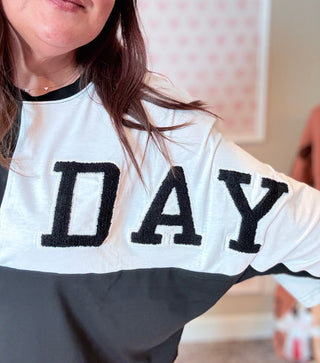 Close-up of black and white color block tee with sequin-outlined football patch, ideal for casual team spirit looks.