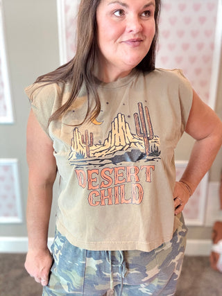 Person wearing a sleeveless shirt with 'Desert Child' design in a casual setting