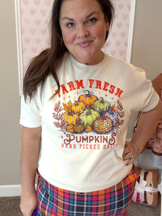 Person wearing a 'Farm Fresh Pumpkins' t-shirt with a graphic design.