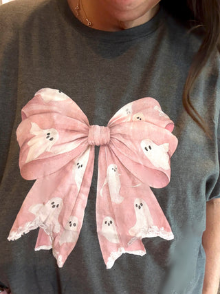 Gray t-shirt with a large pink bow and ghost designs on a plain background