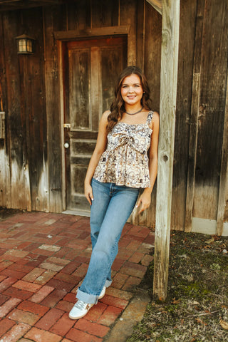 Woman standing in front of a wooden building on a brick path