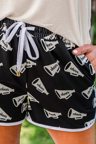 Close-up view of the pom-pom details and drawstring waistband on the Shake Your Pom Poms Drawstring Everyday Shorts.