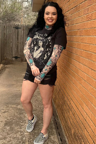 Sheer mesh top with tattoo art design and soft western floral touches—playful and one-of-a-kind styled under a graphic tee.