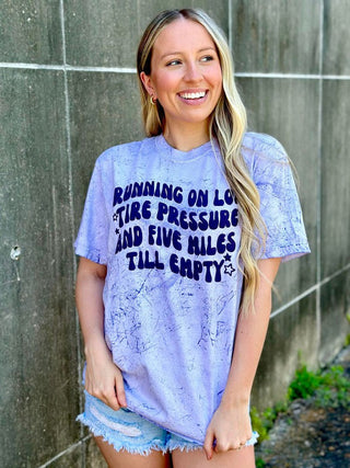 Woman wearing a light blue tie-dye t-shirt with text design.