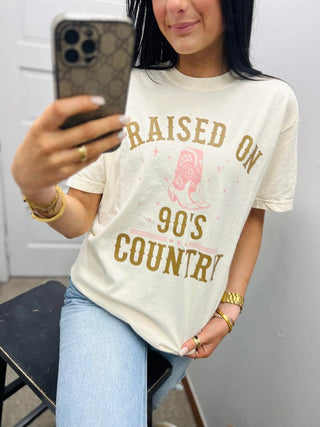 Person wearing a t-shirt with text and graphics, taking a mirror selfie.