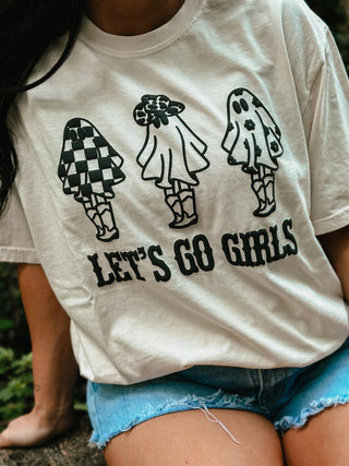 White t-shirt with black graphics and 'Let's Go Girls' text worn by a person outdoors.