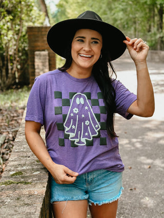 Woman wearing a purple t-shirt with a ghost graphic outdoors