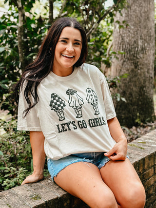 Woman wearing a 'Let's Go Girls' t-shirt in a natural setting