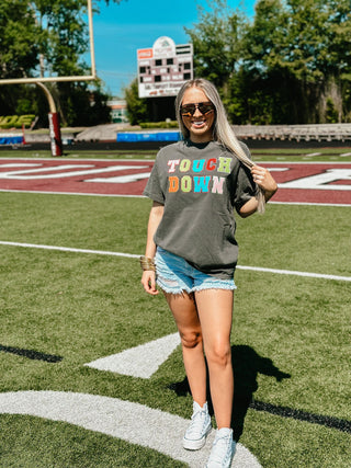 Woman wearing a 'Tough Down' t-shirt on a football field