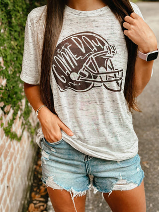 Person wearing a gray t-shirt with a football helmet graphic and 'Game Day' text, paired with denim shorts.