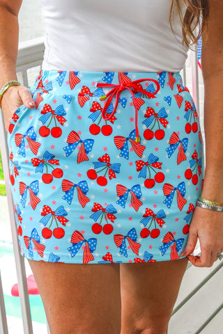 Skirt with cherry and bow pattern on a light blue background