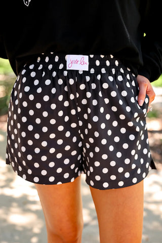 Black and white polka dot boxer shorts with elastic waistband, side pockets, and relaxed fit by Jess Lea. 